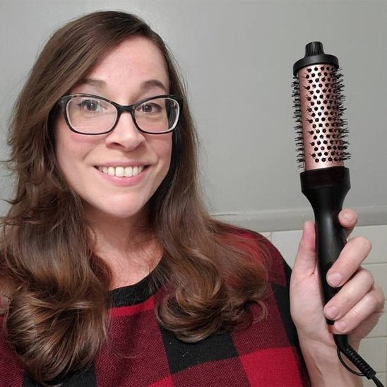 Woman smiling while holding Brosse Chauffante Professionnelle - Lissage Parfait & Volume Éclatant